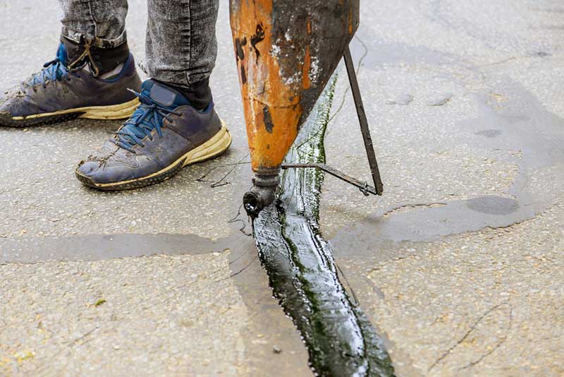 driveway water leak sealing of asphalt crack